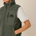 Sherpa Weste - Unisex mit Reißverschluss und Taschen, getragen von Person mit Hand in Tasche, zeigt WESORA-Logo auf Brust.
