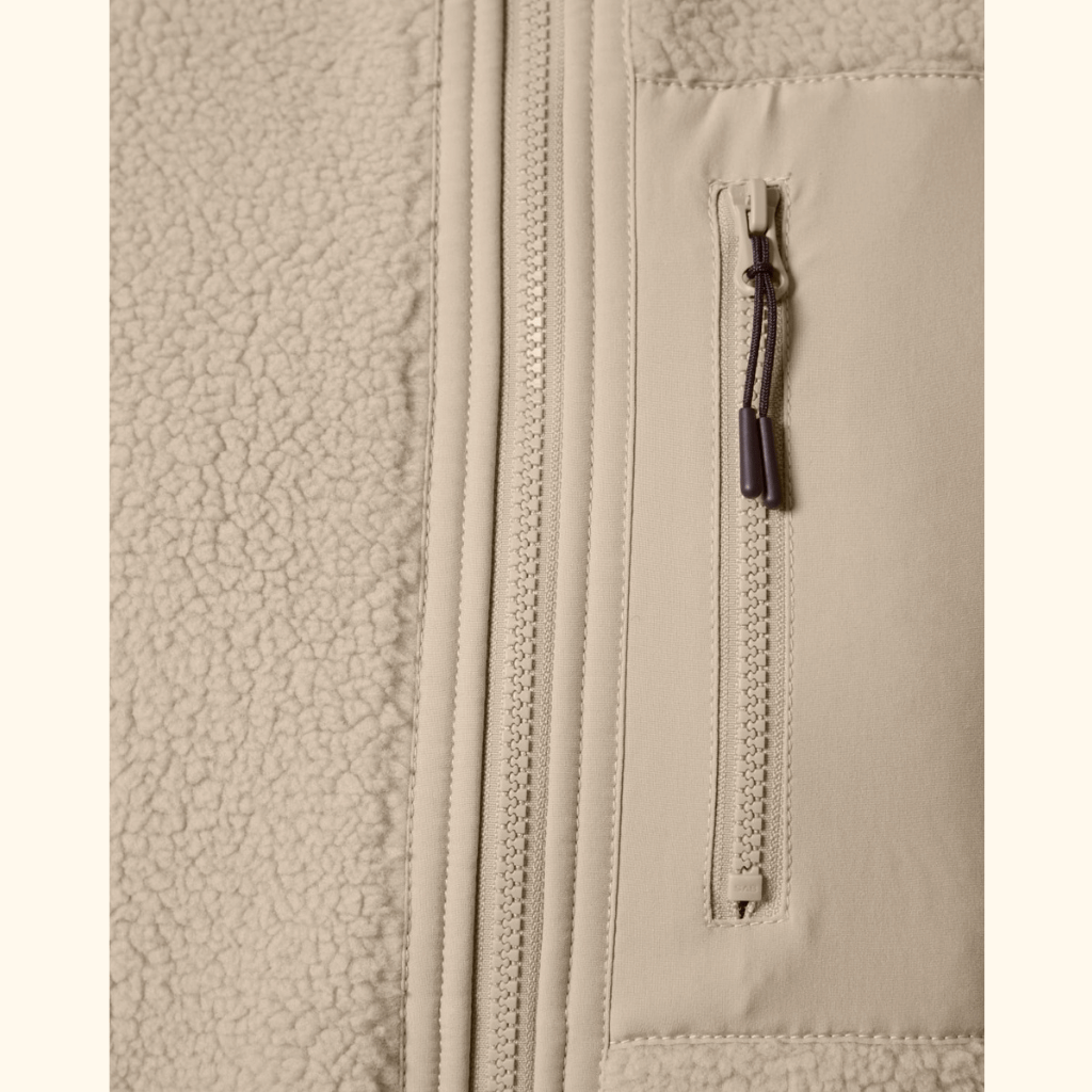 Sherpa Weste - Unisex mit flauschiger Fleece-Struktur links und glatter Stofffläche rechts, vertikalem Hauptreißverschluss und kleiner Brusttasche mit Kordelzipper.