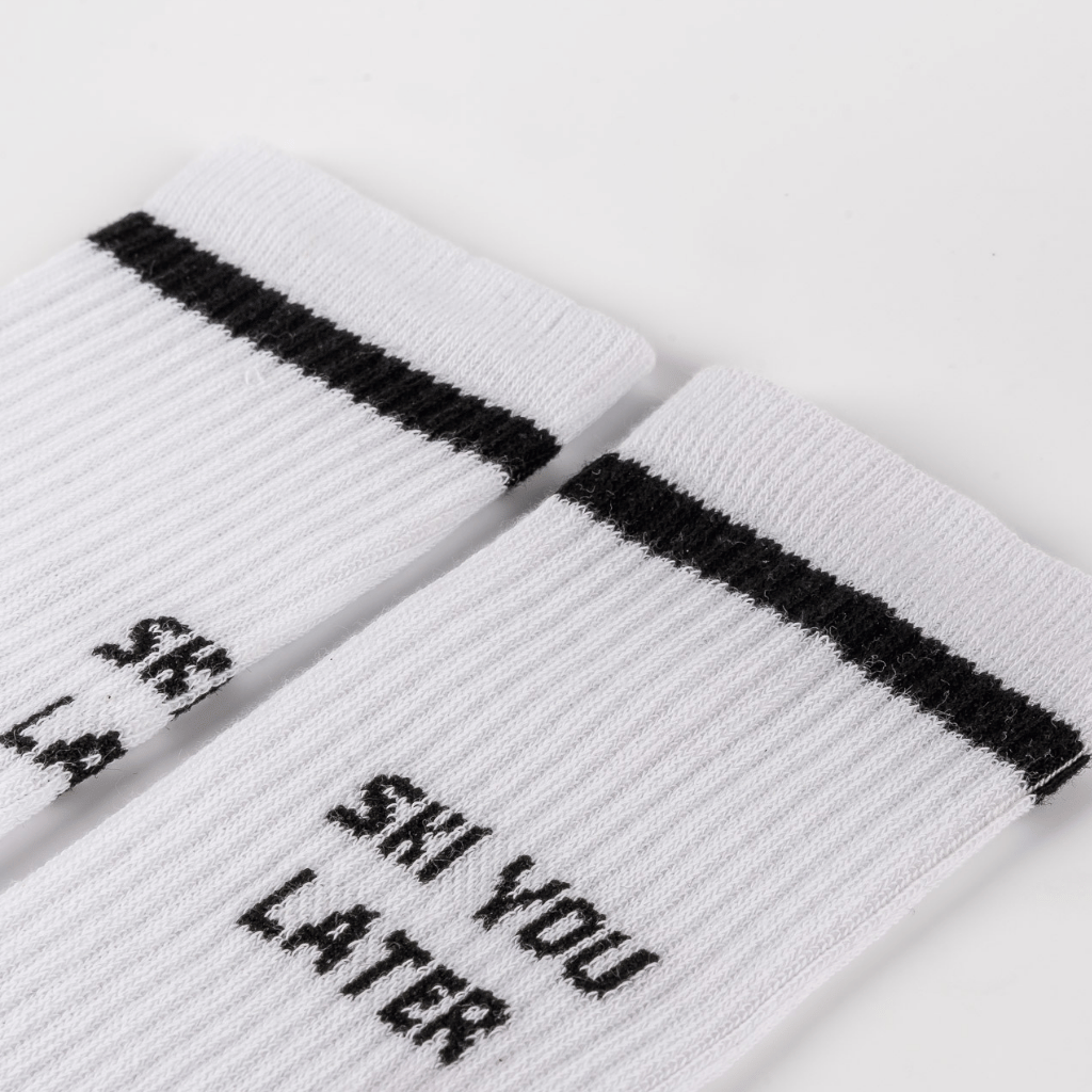 Socks - Ski you later mit schwarzem Streifen und Slogan, aus Baumwolle für Wärme und Komfort, Nahaufnahme der gerippten Bündchen.