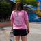 Take me to the Mountains - Unisex T-Shirt mit großem Rückenprint, gehalten von Person mit Longboard, fotografiert auf sonnigem Boardwalk, Rückansicht.