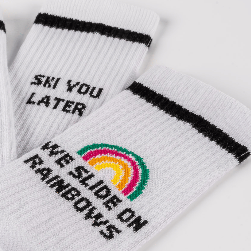 Socks - WESORA mit schwarzen Streifen und bunten Stickereien SKI YOU LATER und Regenbogen I RIDE ON RAINBOWS, Nahaufnahme.