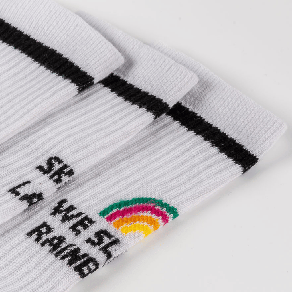 Socks - WESORA mit Regenbogenmotiv und schwarzem Streifen am Bündchen, gestapelt, nahaufgenommen.