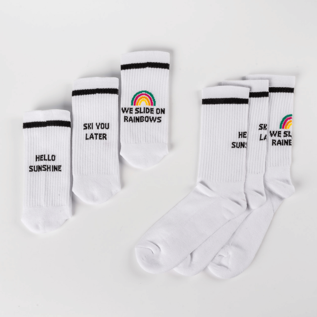 Socken-Bundle mit drei Designs: HELLO SUNSHINE, SKI YOU LATER, WE SLIDE ON RAINBOWS, flach hingelegt, zwei Größen, ideal für Mix und Match.