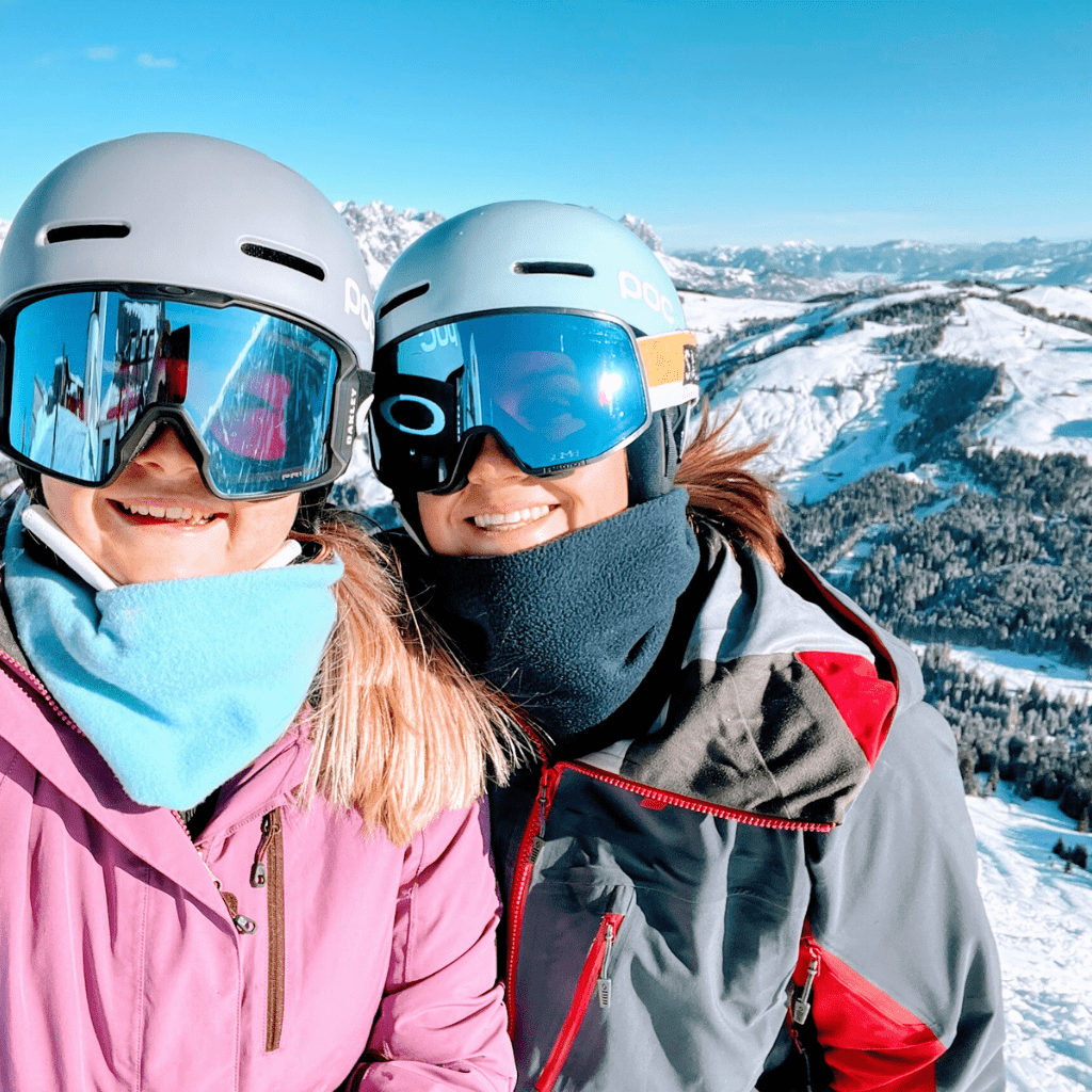 Selfie von zwei Freundinnen beim Skifahren mit Skihelm und Skibrille in verschneiter Berglandschaft