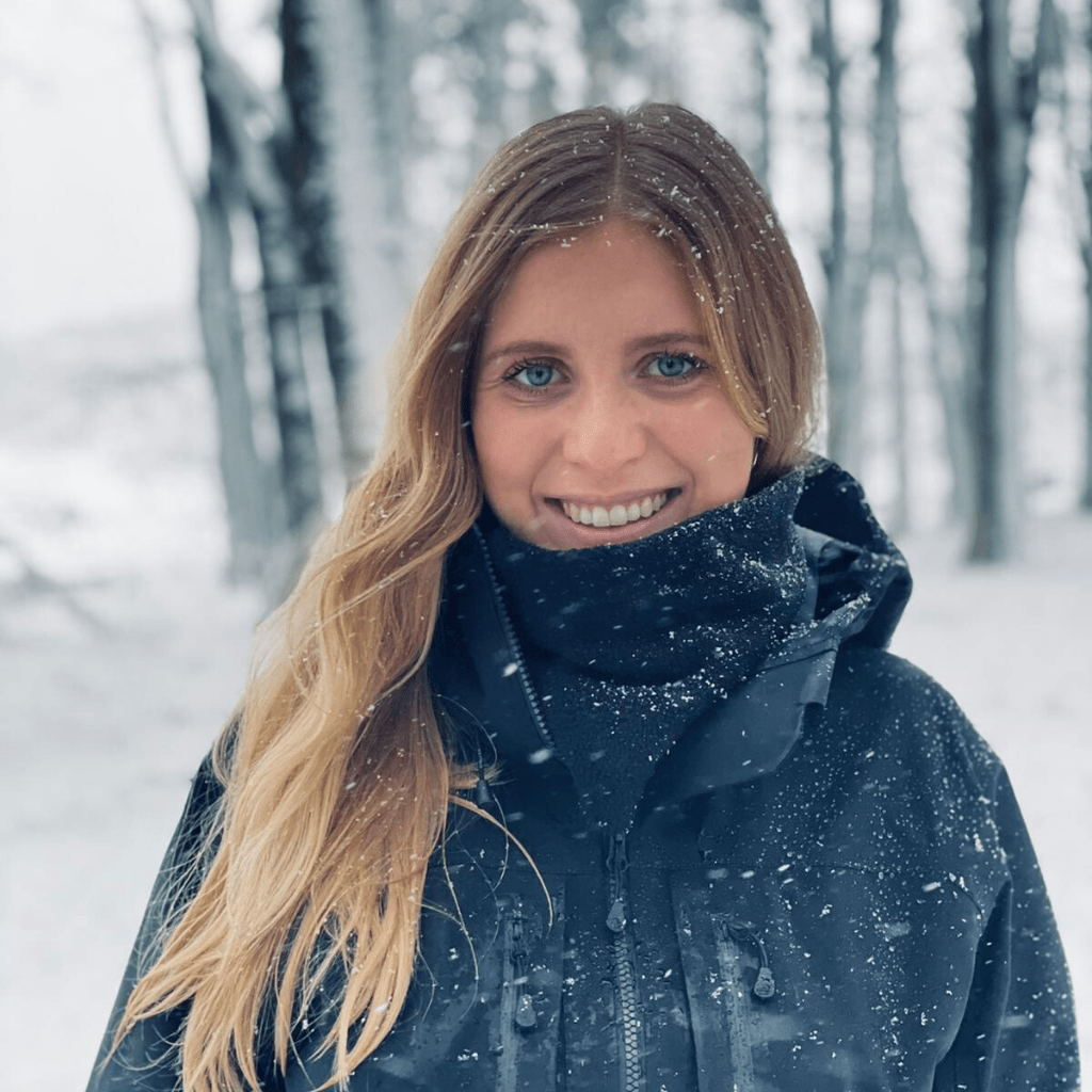 Blonde Dame trägt schwarzen WESORA Neckwarmer in verschneiter Waldlandschaft