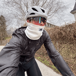 Fleece Neckwarmer - Off White, getragen von einem Radfahrer auf einer ruhigen Straße bei kühlem Wetter, mit weißem Helm und Sonnenbrille.